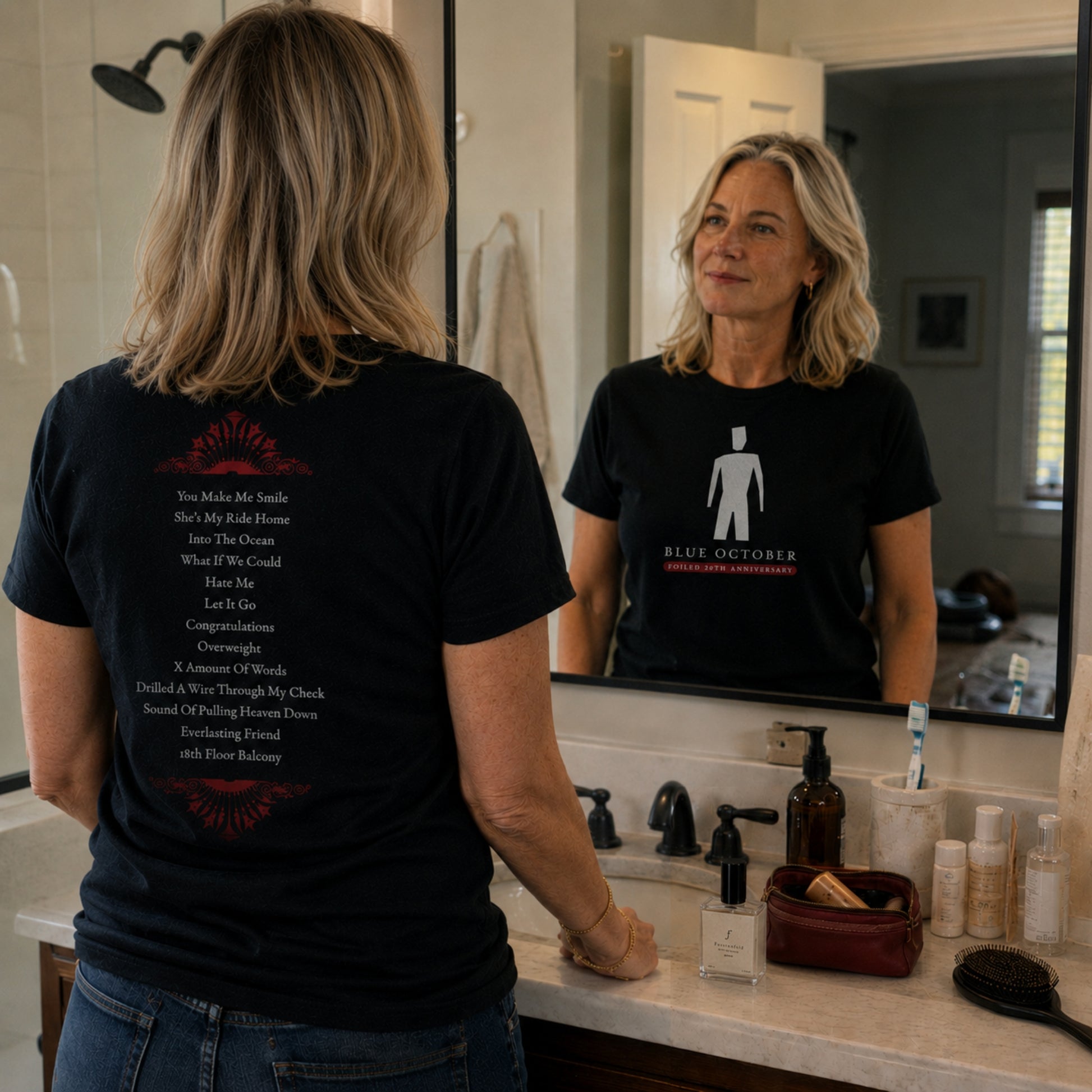 A woman at a mirror in the Blue October Broken Man T-shirt showing front and back.