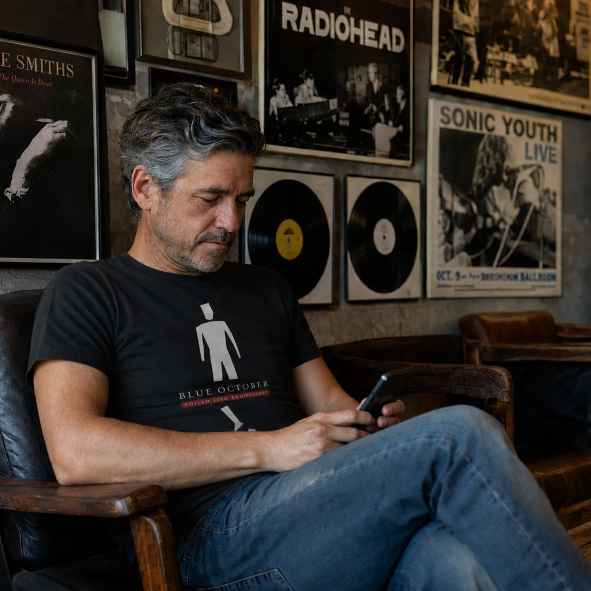 A seated guy in the black Blue October Broken Man Tee.